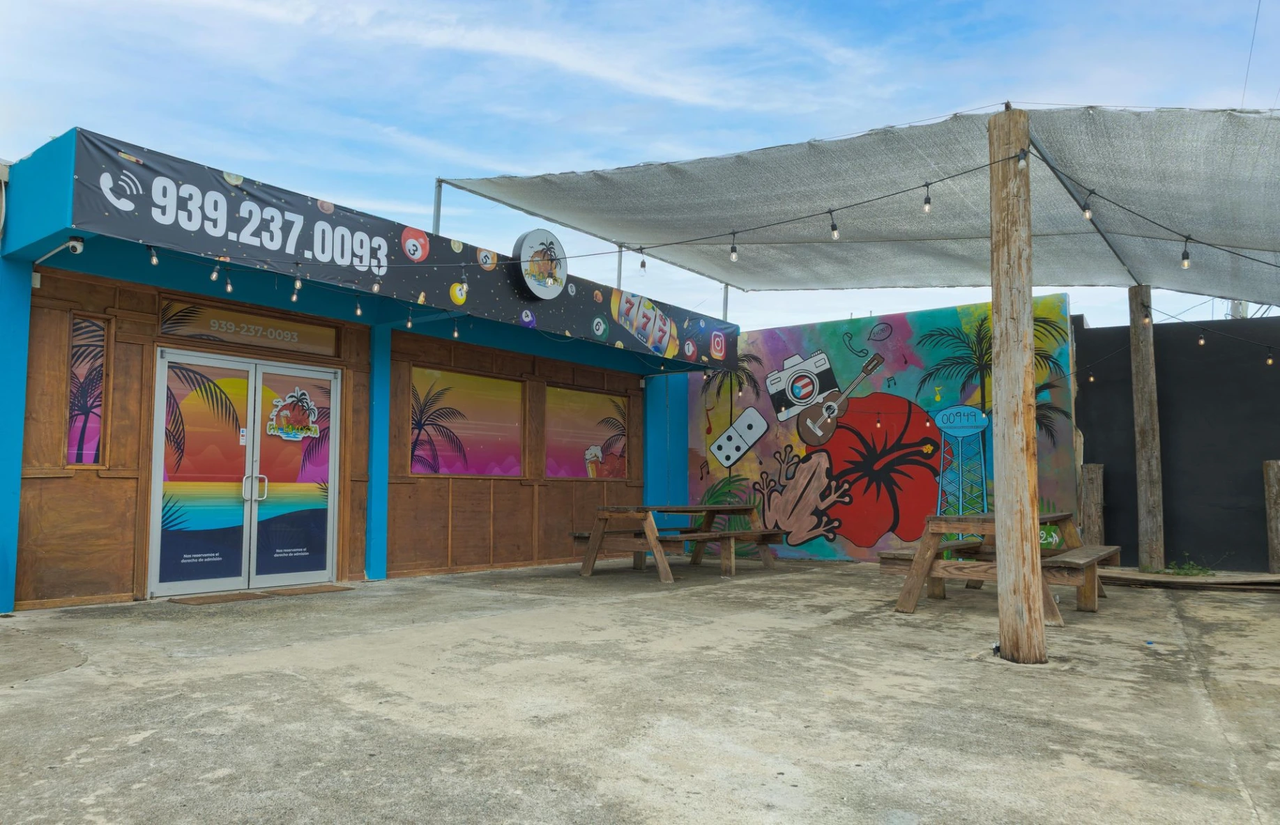 Fachada y terraza de negocio con mural colorido en Puerto Rico