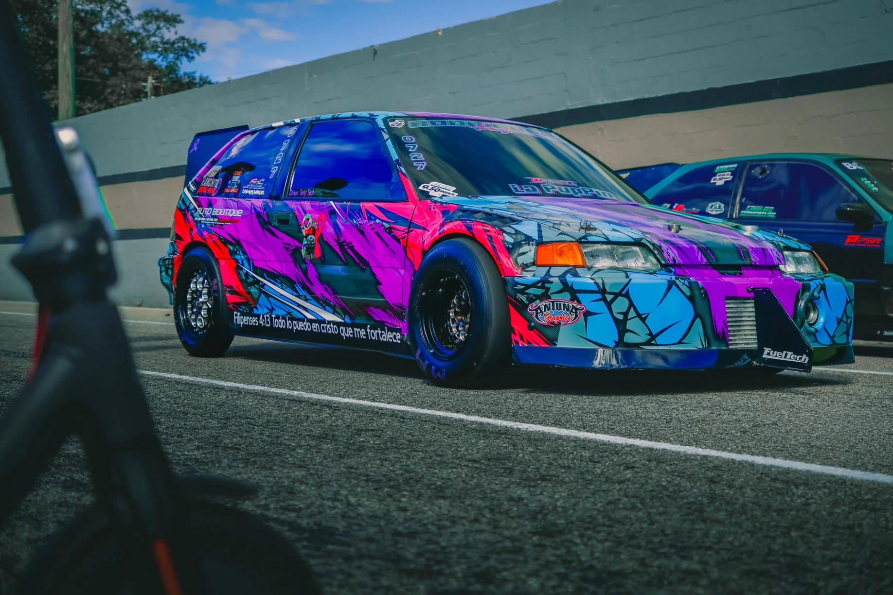 Automóvil modificado de carreras con diseño azul y violeta