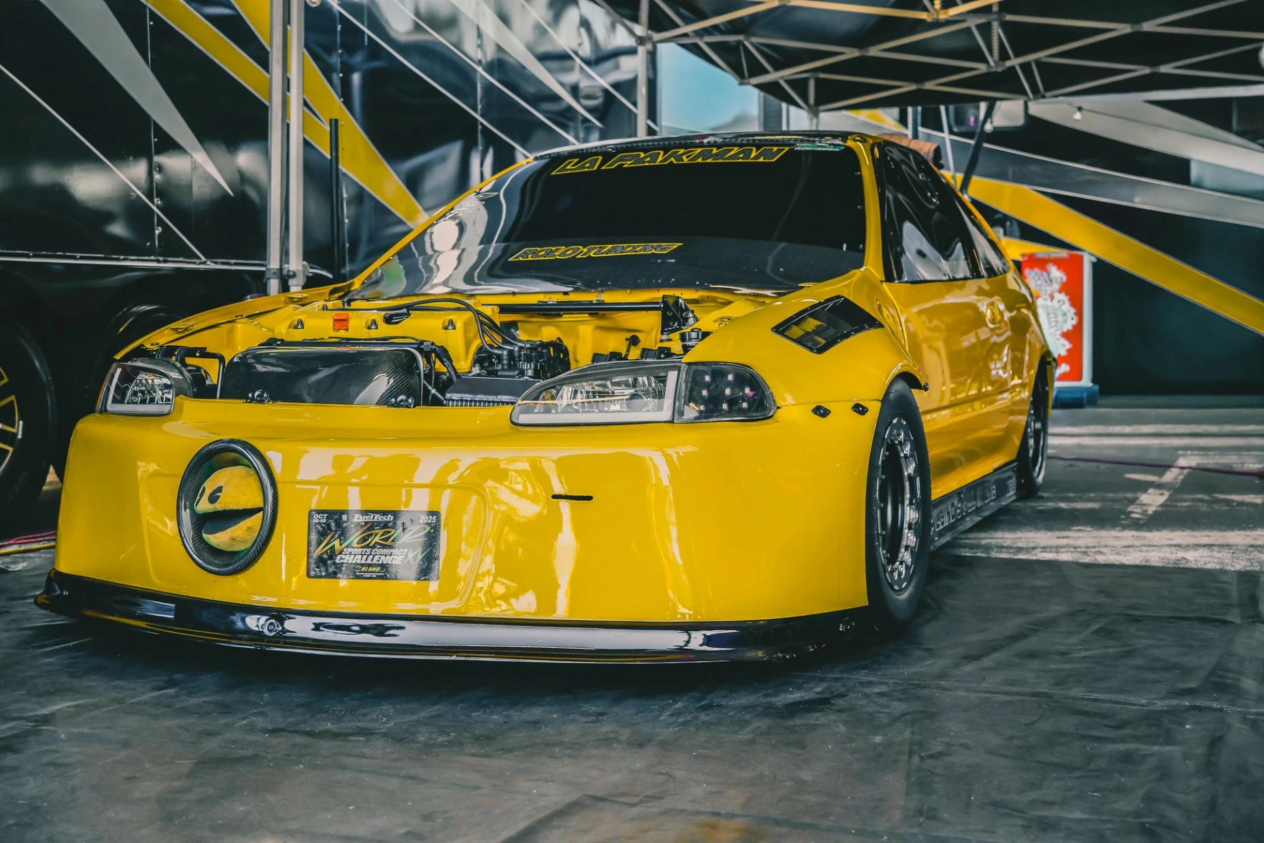 Automóvil amarillo preparado para carreras en evento de autos
